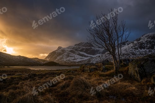 Preview: Scenic view of the lake surrounded by snowy mountains during sunset