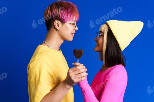 Preview: Asian teenagers in eyeglasses posing with heart lollipop