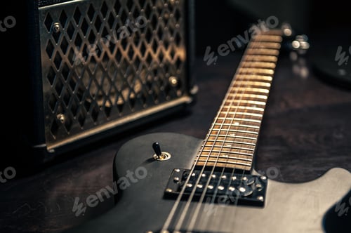 Preview: Close-up, black electric guitar on a dark background.
