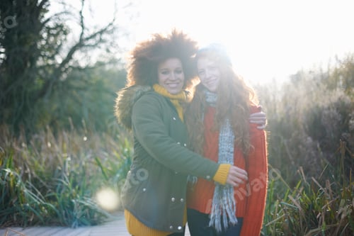 Preview: Friends hugging looking at camera smiling