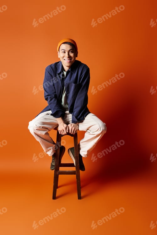 Preview: Elevated elegance: stylish asian man on wooden stool