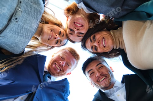 Preview: Low angle view of a group of international happy businesspeople in circle.