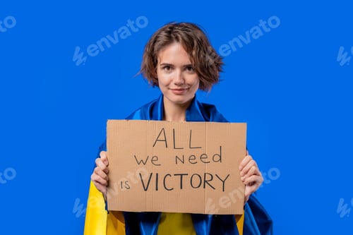 Preview: Ukrainian woman with cardboard All we need is victory on blue background. Ukraine will win war.