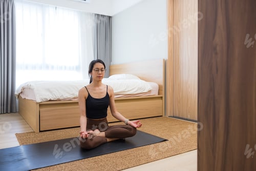 Preview: Woman practicing meditation and relaxation at home