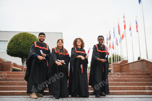 Preview: Diverse students celebrating graduation, holding diplomas