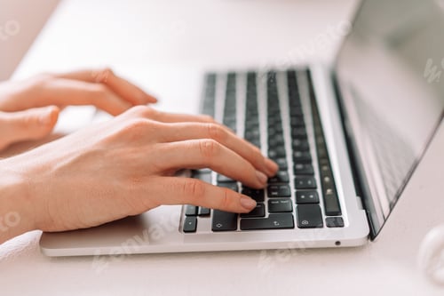 Preview: Lady typing on laptop keyboard at table