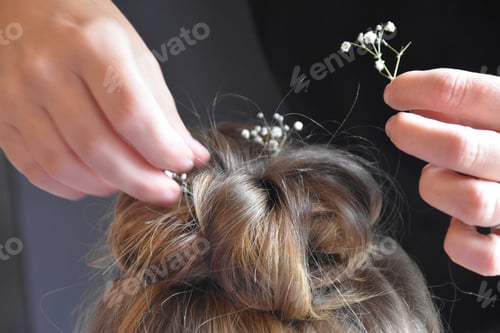 Preview: Woman's Hair Being Decorated with White Flowers