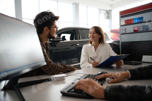 Preview: Woman and man talking with dealer about buying car signing documents