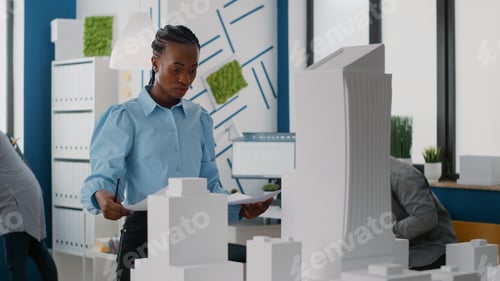 Preview: Portrait of woman architect looking at blueprints plan to find inspiration for construction layout