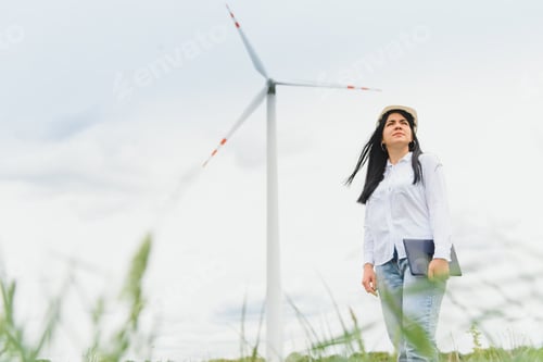 Preview: Women engineer using tablet for working on site at wind turbine farm