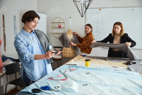 Preview: Adult taking photo of fabric under sewing patterns