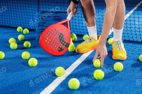 Preview: Padel tennis training with racket and multiple balls on blue court