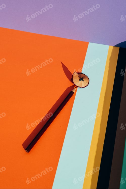 Preview: Pencil and shavings from sharpening, on colored striped papers b