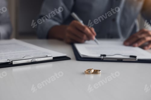 Preview: Husband and wife crate signing divorce documents at lawyer office.