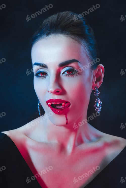 Preview: sexy vampire woman licking her lips on dark background