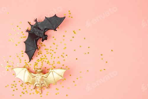 Preview: Top view of Halloween decoration with plastic bats over pink background. Party, invitation