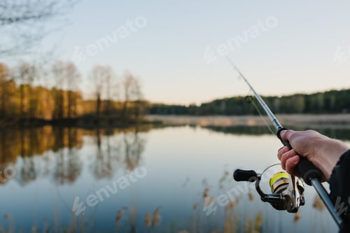 Preview: Fishing. Fisherman with rod, spinning reel on the river bank. Fishing for pike, perch, carp. Fog ag