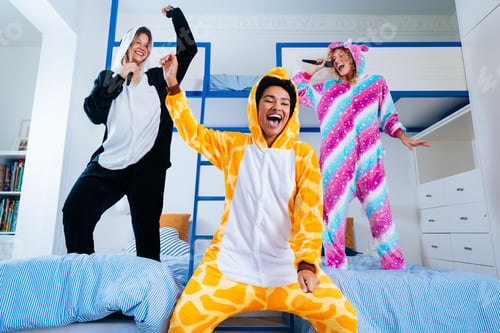 Preview: Multiethnic group of young female friends having pajamas party at home