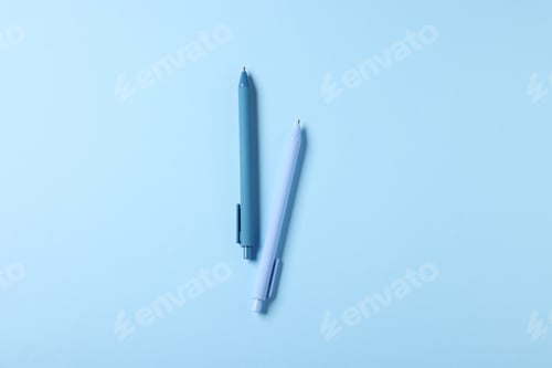 Preview: Stylish pens on light blue background, top view