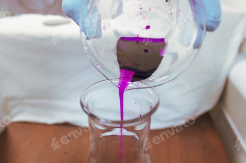 Preview: Person with blue gloves doing experiments with test tubes and purple liquid