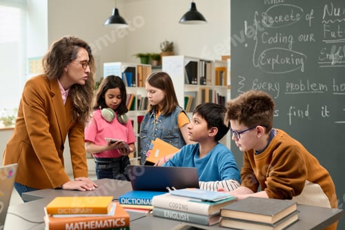 Preview: Teacher Talking to Group of Kids using Computer in Class