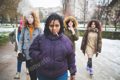 Preview: group of young women walking in the street and smoking cigarette