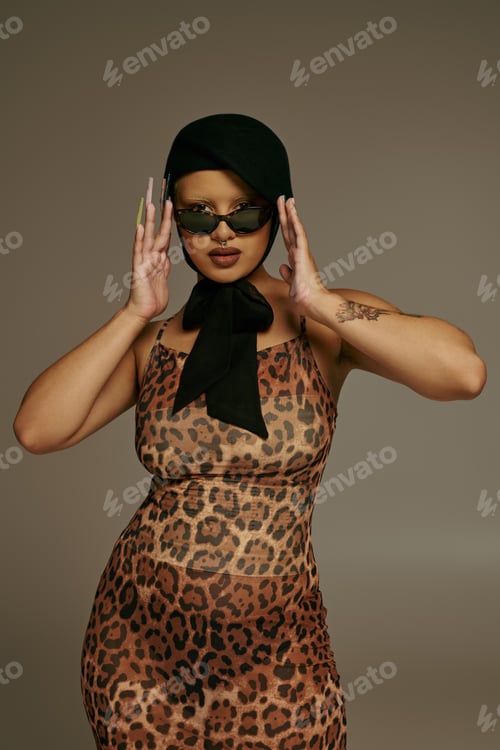 Preview: Young stylish woman poses confidently in a chic leopard print dress and unique accessories