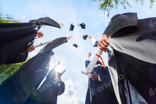 Preview: bottom view of graduated students throwing up hats in front of blue sky
