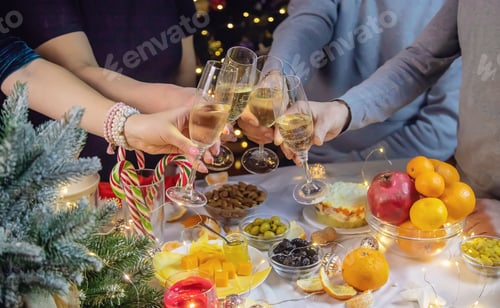 Preview: Champagne in hand against the background of the Christmas tree. People. Selective focus.