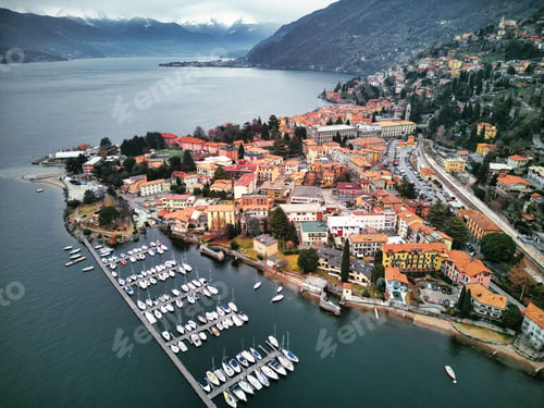 Preview: Drone view of Lake Como surrounded by a town and mountains in the evening in Italy
