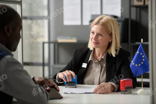 Preview: Mature woman consulting person in EU immigration office