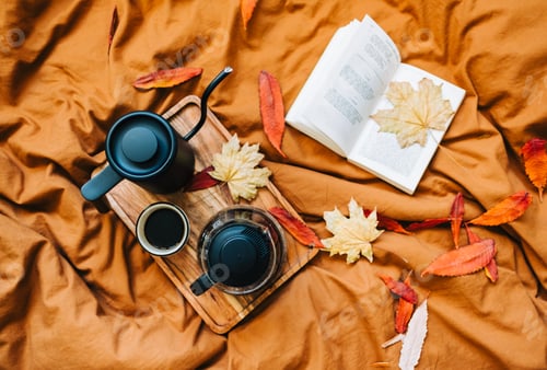 Preview: Open book and brewed coffee on a bed with autumn leaves in the morning, cosy home and calm concept
