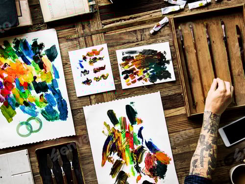 Preview: Aerial view of artist tattoo hand with acrylic painting on paper