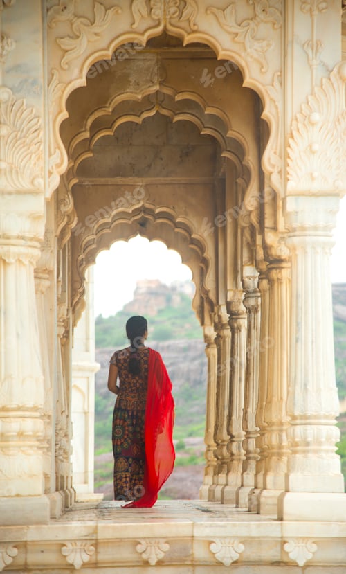 Preview: Indian woman standing between arches and Pillars.