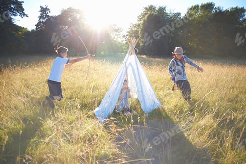 Preview: Small group of young boys playing around teepee