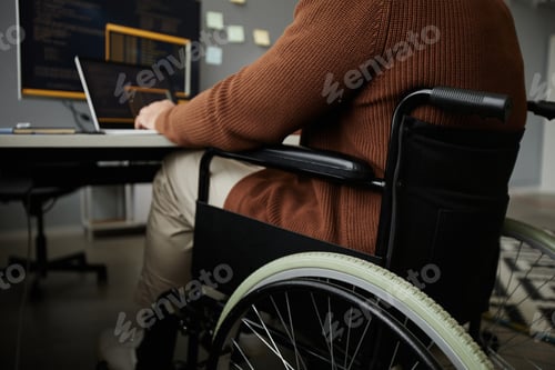 Preview: Close Up of Man with Disability Using Wheelchair Working at Desk