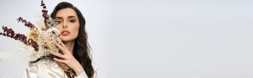 Preview: A young woman with brown hair elegantly poses with blossoms, radiating joy and beauty