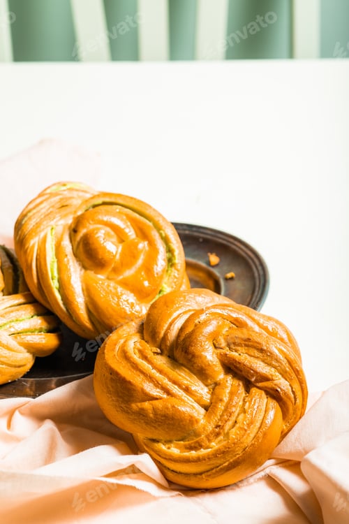Preview: homemade buns with cream and pistachio cream decorated with thyme freshly baked for breakfast