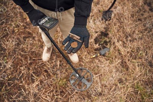 Preview: Old bullets and coin. Man is with metal detector in the field