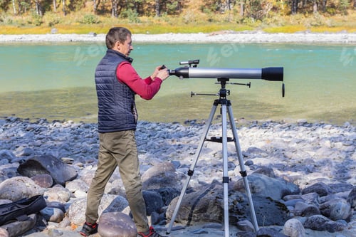 Preview: Amateur astronomer adjusts optical magnifier for viewing at sky with telescope,selective focus
