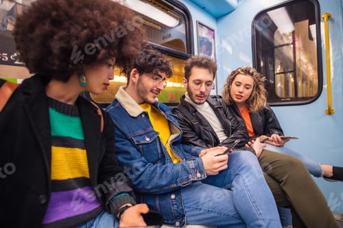 Preview: Group of four people friends travelling subway using smartphone addicted to social and viral trends