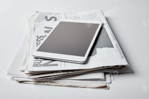 Preview: digital tablet with blank screen near business newspapers with articles on white