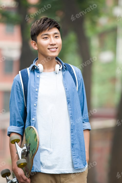 Preview: Male college student with skateboard on campus