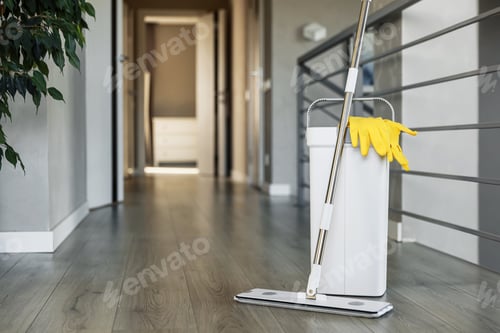Preview: Cleaning supplies: mop, gloves, bucket with wringer on wooden laminate floor