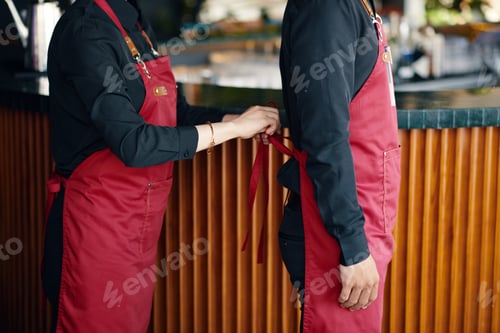Preview: Waitress Helping Coworker to Tie Apron