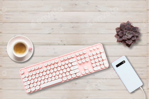 Preview: Computer keyboard pink color and smartphone against wood background