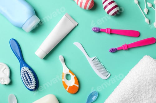Preview: Flat lay composition with baby toothbrushes and toiletries on color background