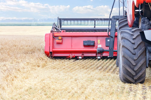 Preview: Fragment of a large combine harvester harvesting wheat on a summer day