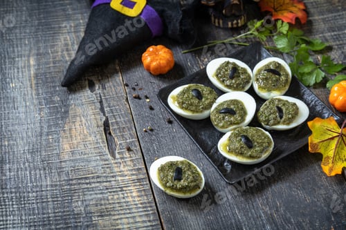 Preview: Halloween funny idea for party food. Halloween creative stuffed eggs with pesto sauce.
