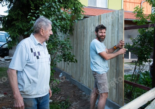 Preview: Men Building a Wooden Fence on a Sunny Day